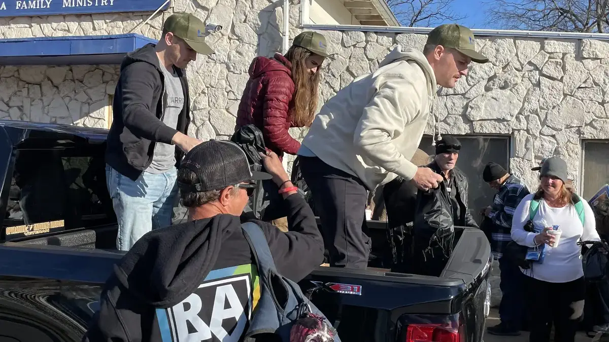 Volunteers distributing supplies from a pickup truck during community outreach.